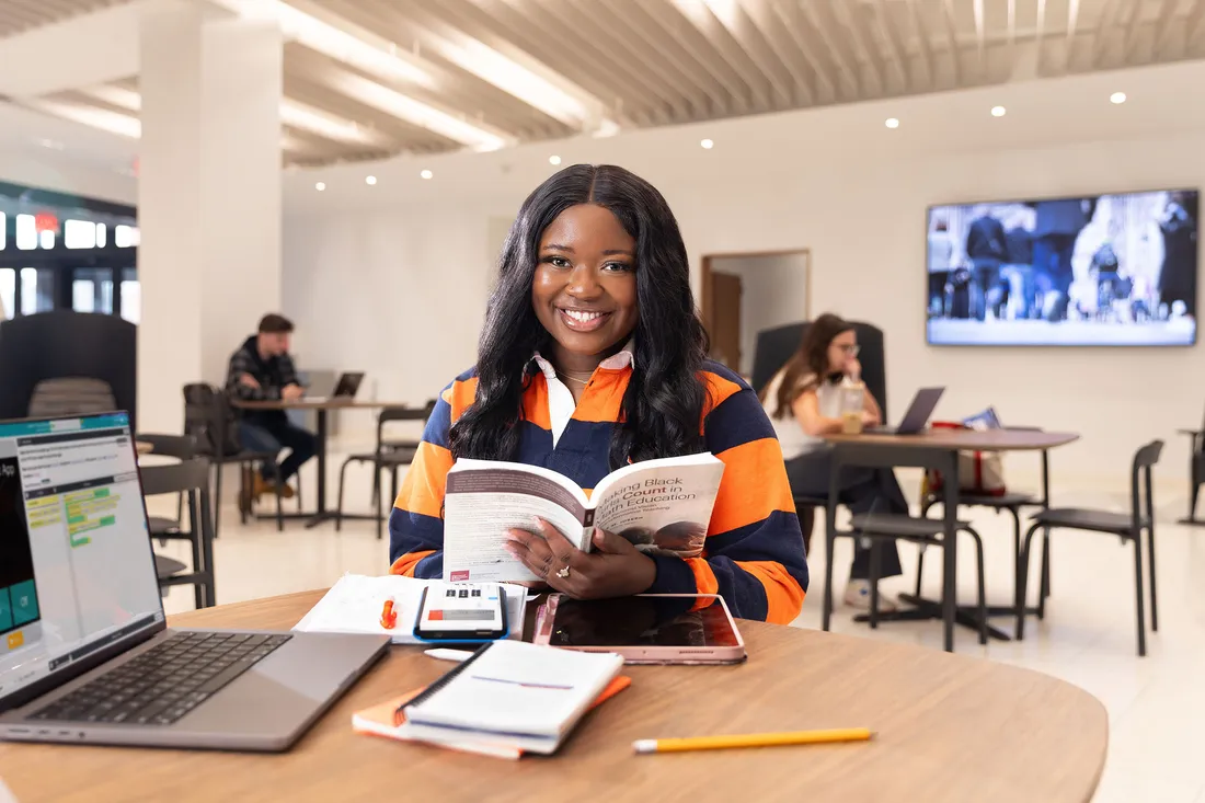 An entrepreneurship student sitting and smiling.