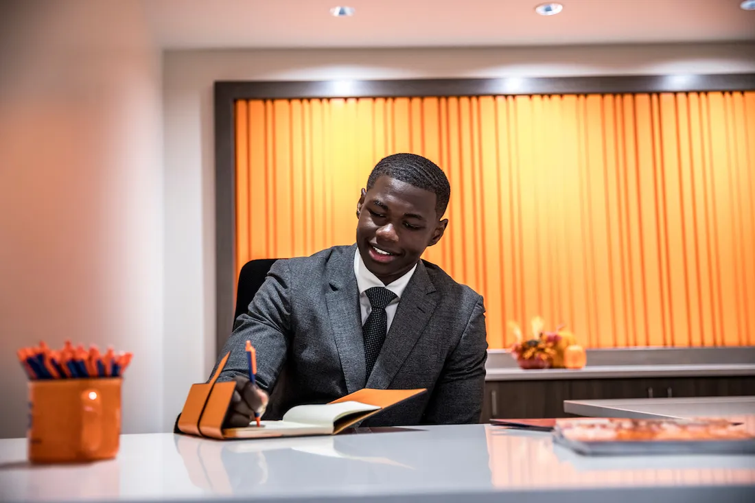 Bakary Darboe writing at a desk.