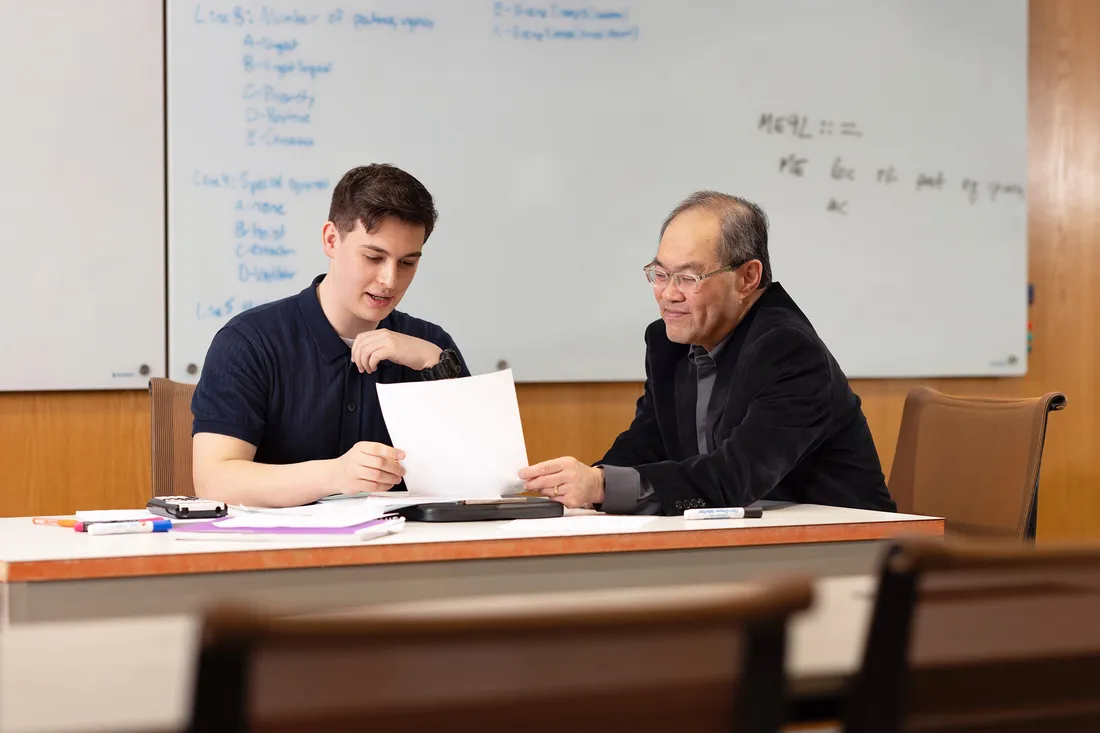 Benjamin Johnson at a table with Professor Shiu Kai Chin.