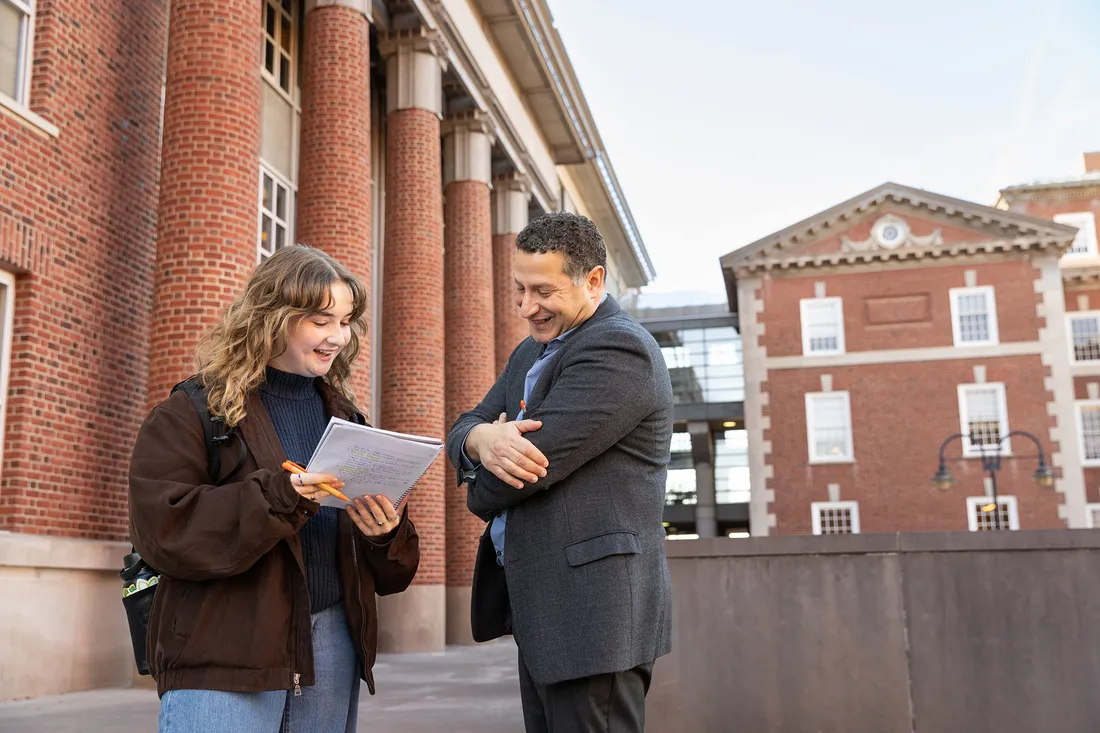 Student and professor talking outside.