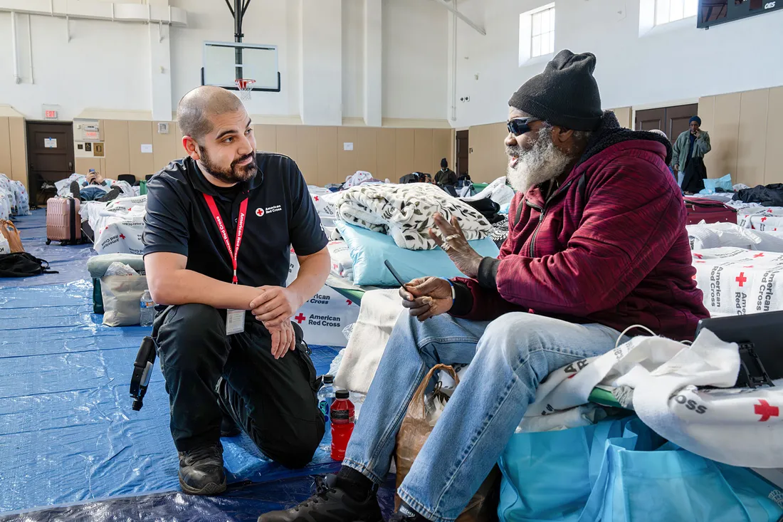 Rob Rivera taking to someone in a red cross shelter.