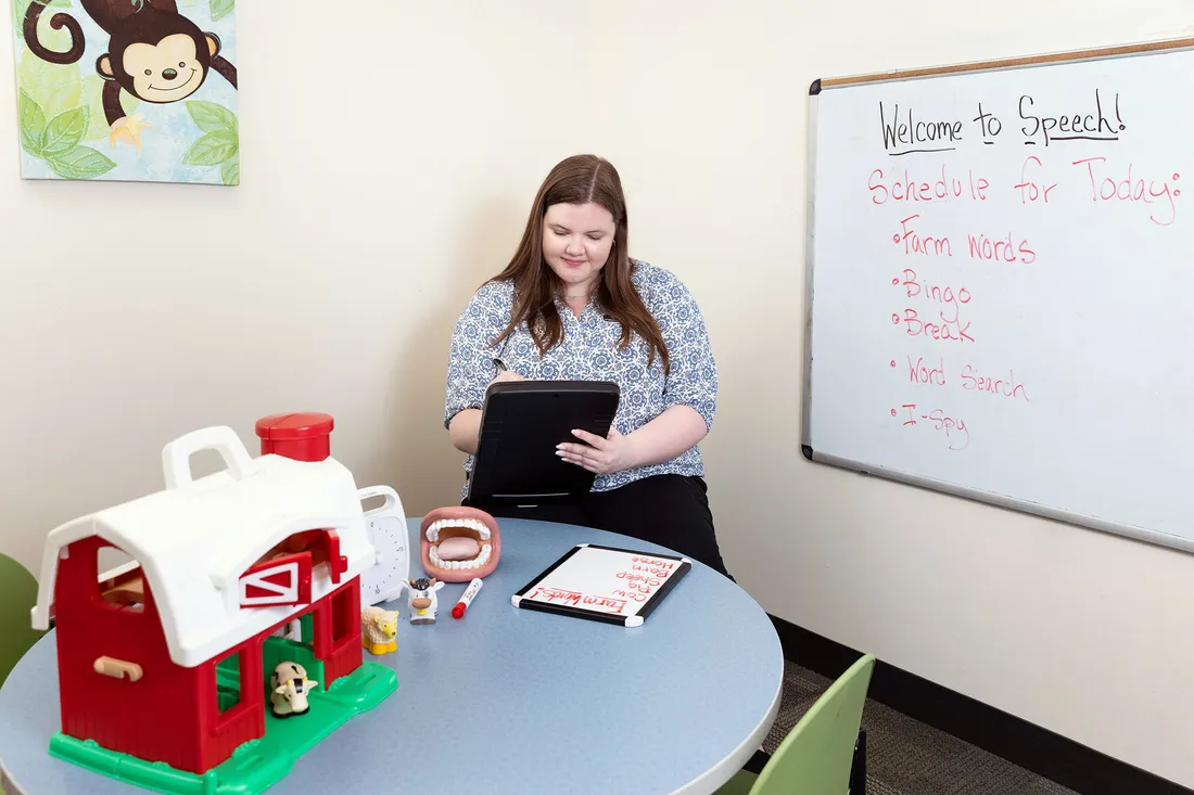 Violet Cabot in a speech classroom working on an ipad.