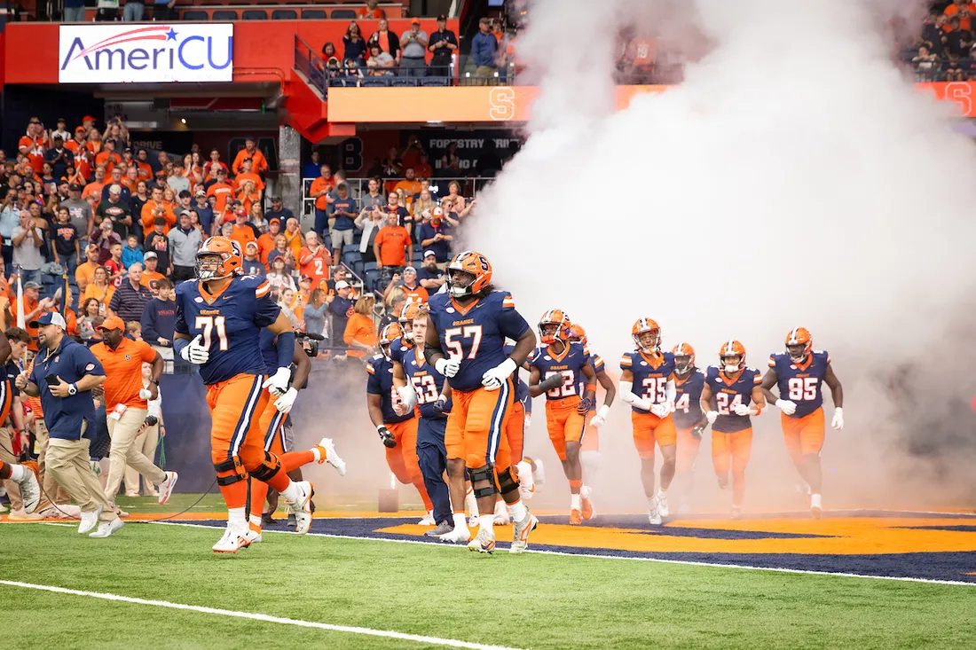 Syracuse Football Players running out onto the field.