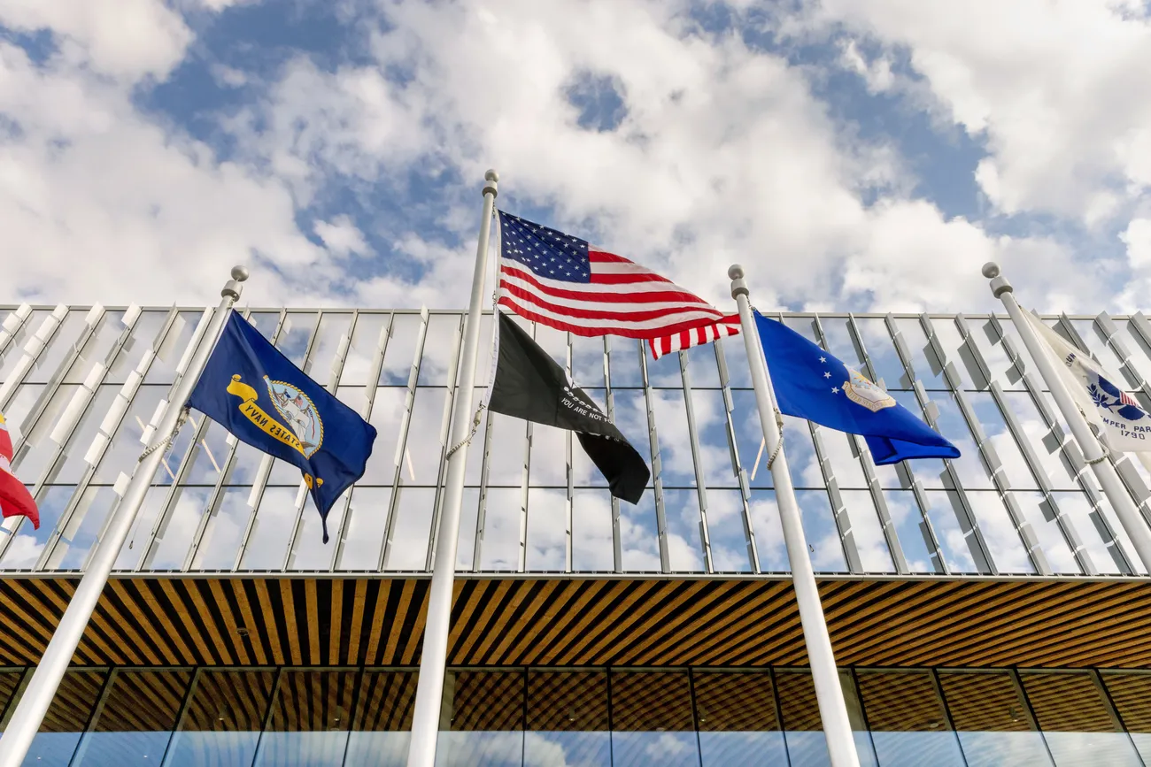 Flags flying outside of the Institute for Veterans and Military Families at Syracuse University (IVMF).