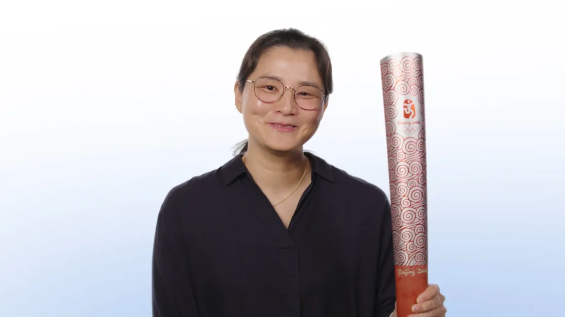 Jeeyoon “Jamie” Kim holding an Olympic Torch.