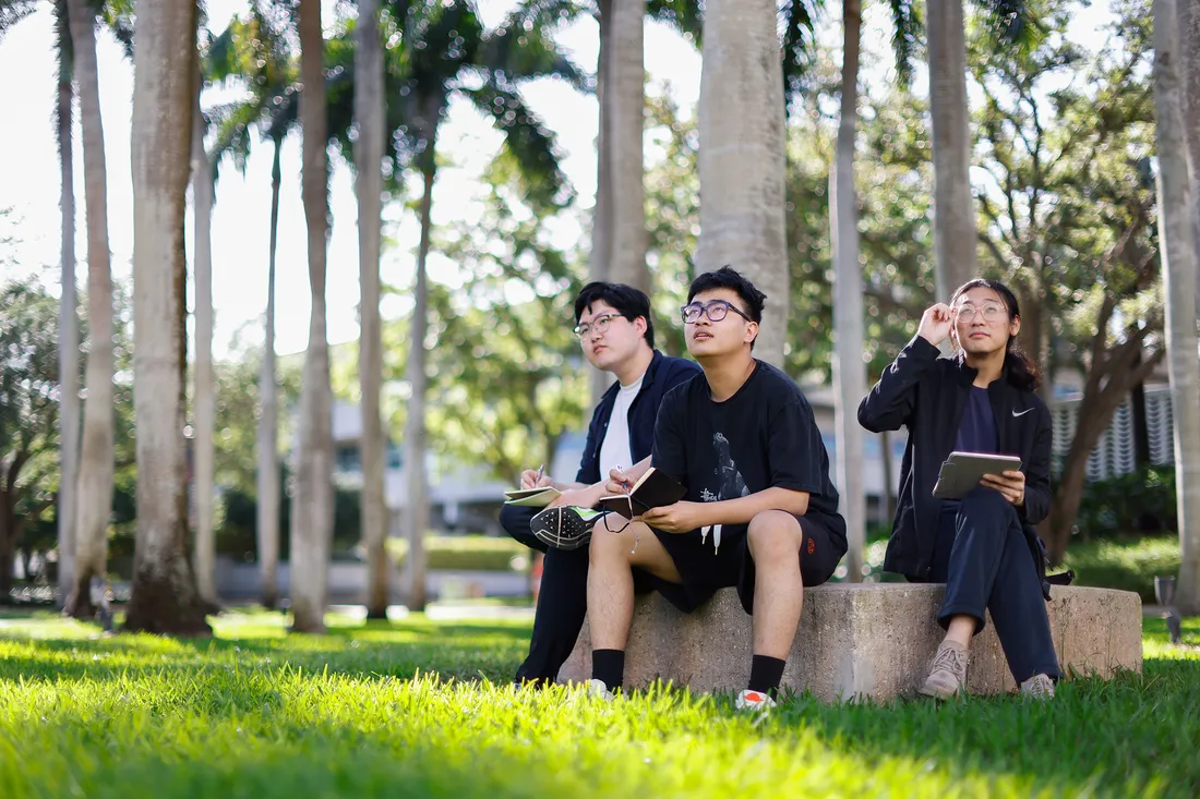 Three people sitting outside.