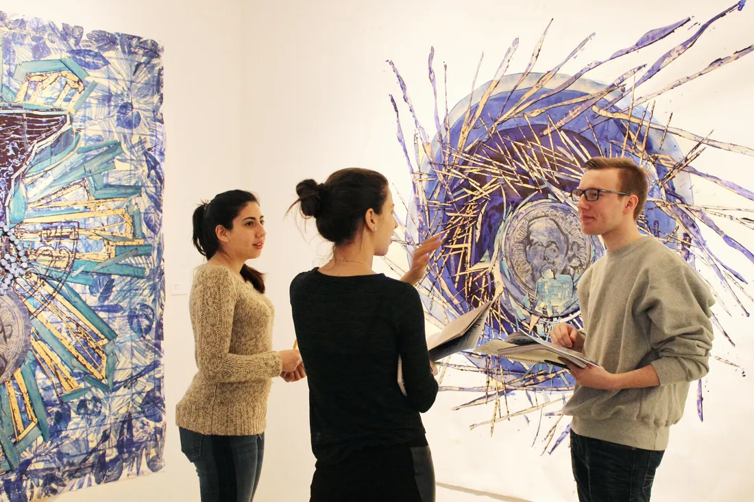 Three students talking in the Point of Contact gallery.