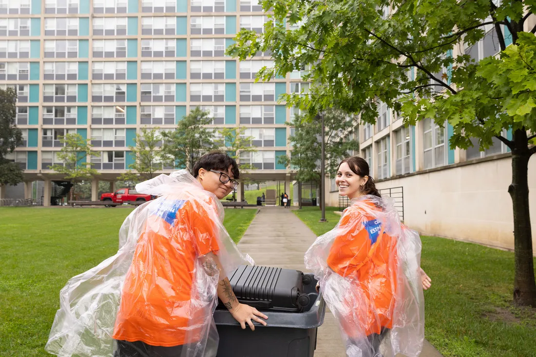 People rolling a bin.