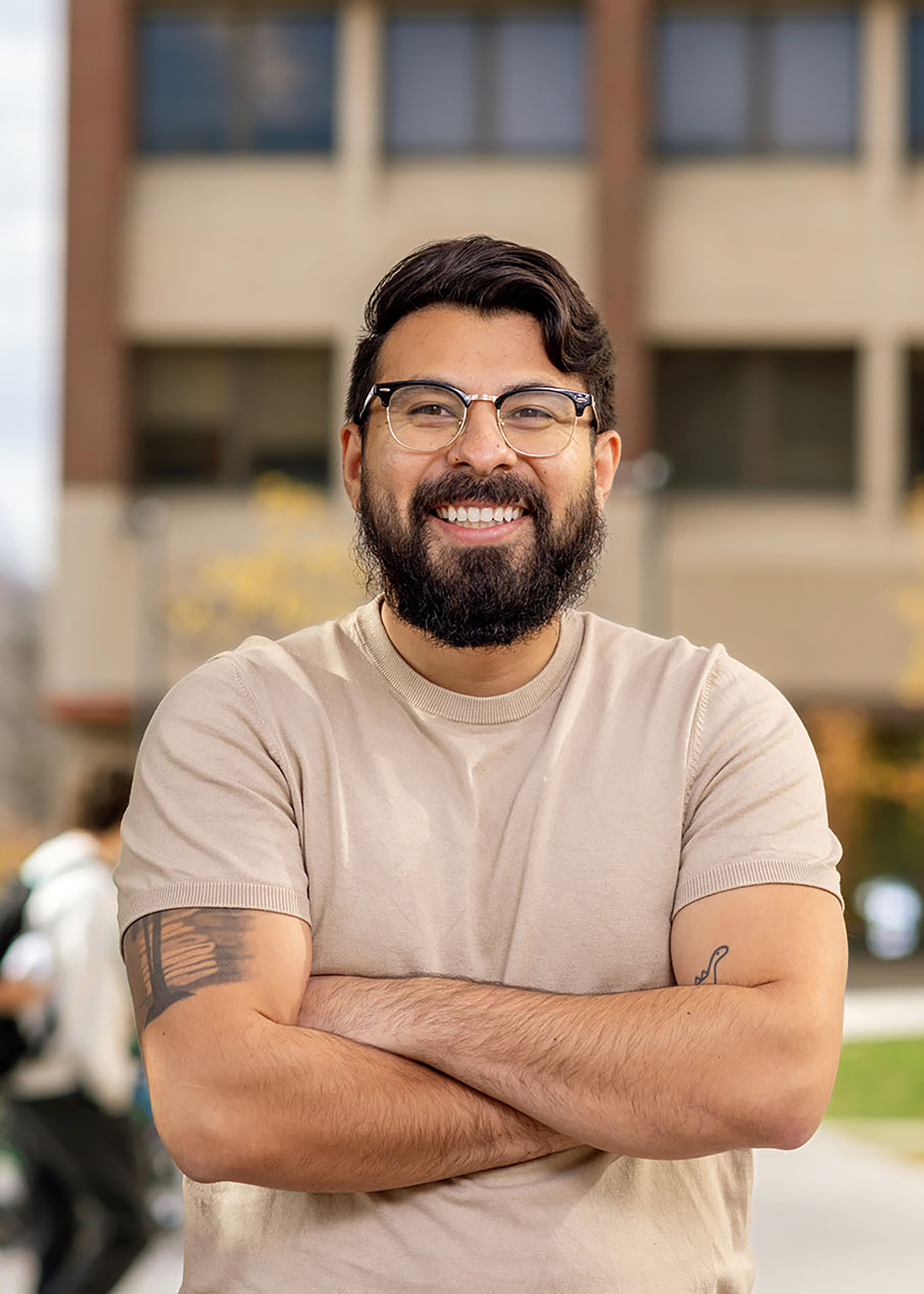 Jurgen Baeza Banal in front of a Syracuse University building smiling.