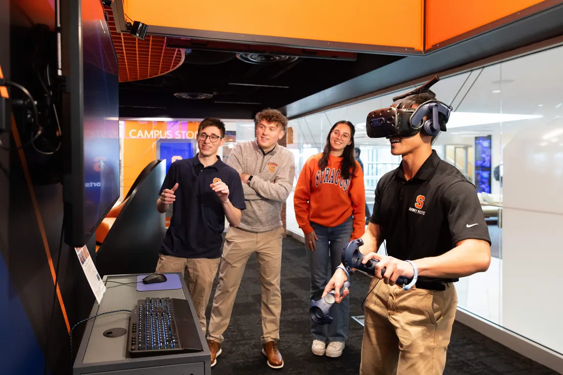 Students watching a student use a VR gaming set in the Esports Center.