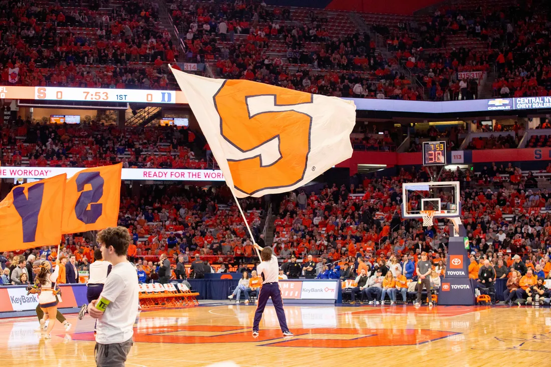 Student waiving a Syracuse University flag in the JMA Wireless Dome.