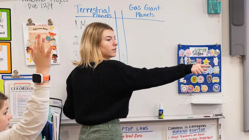 A student teaching a classroom.