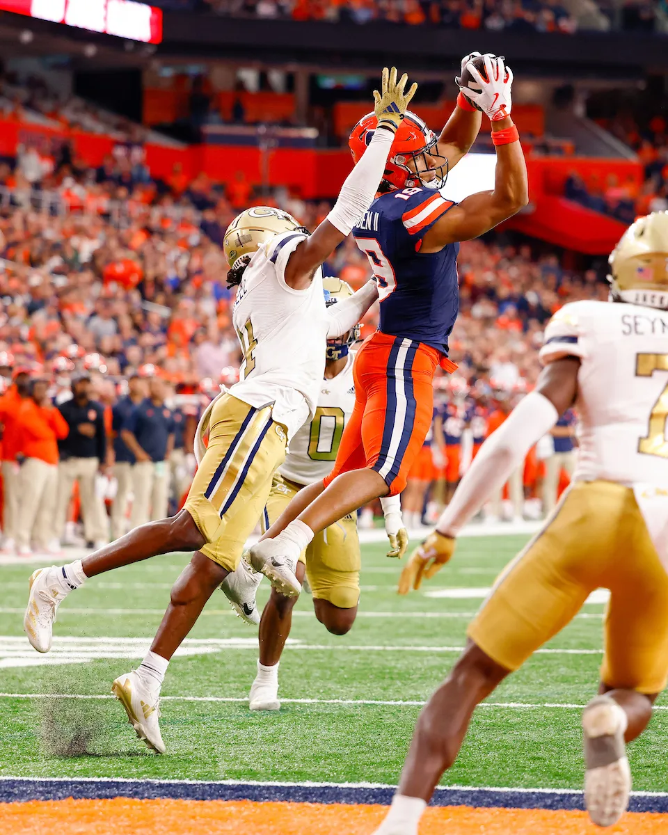 Oronde Gadsden catching a football on the field of the JMA Wireless Dome.