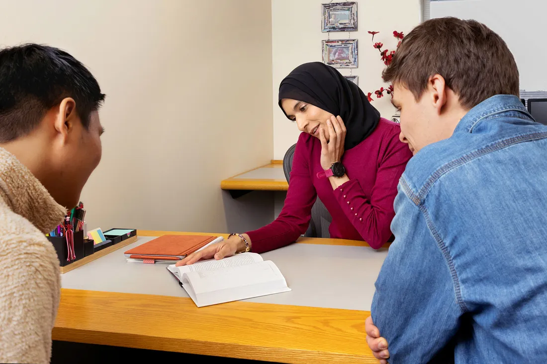 Sabba Siddiki talking to students at a table.