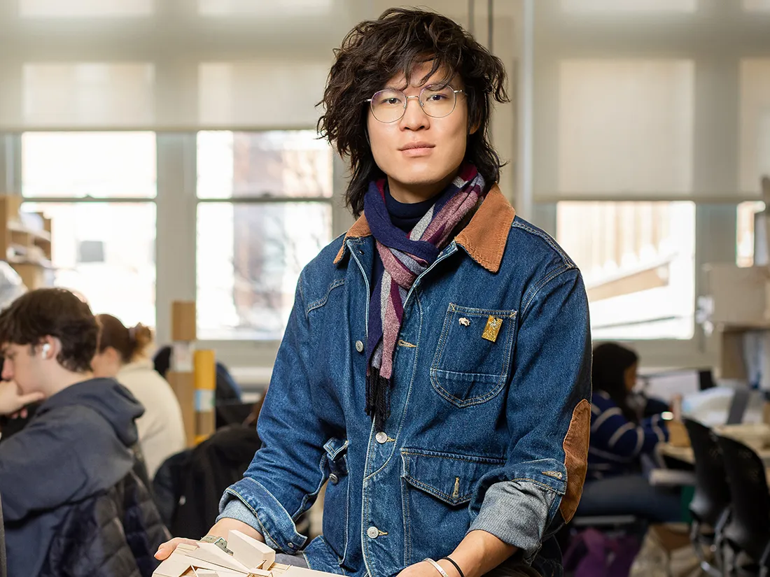 A portrait of Qianzhen Li posed with the architecture studio in the background.