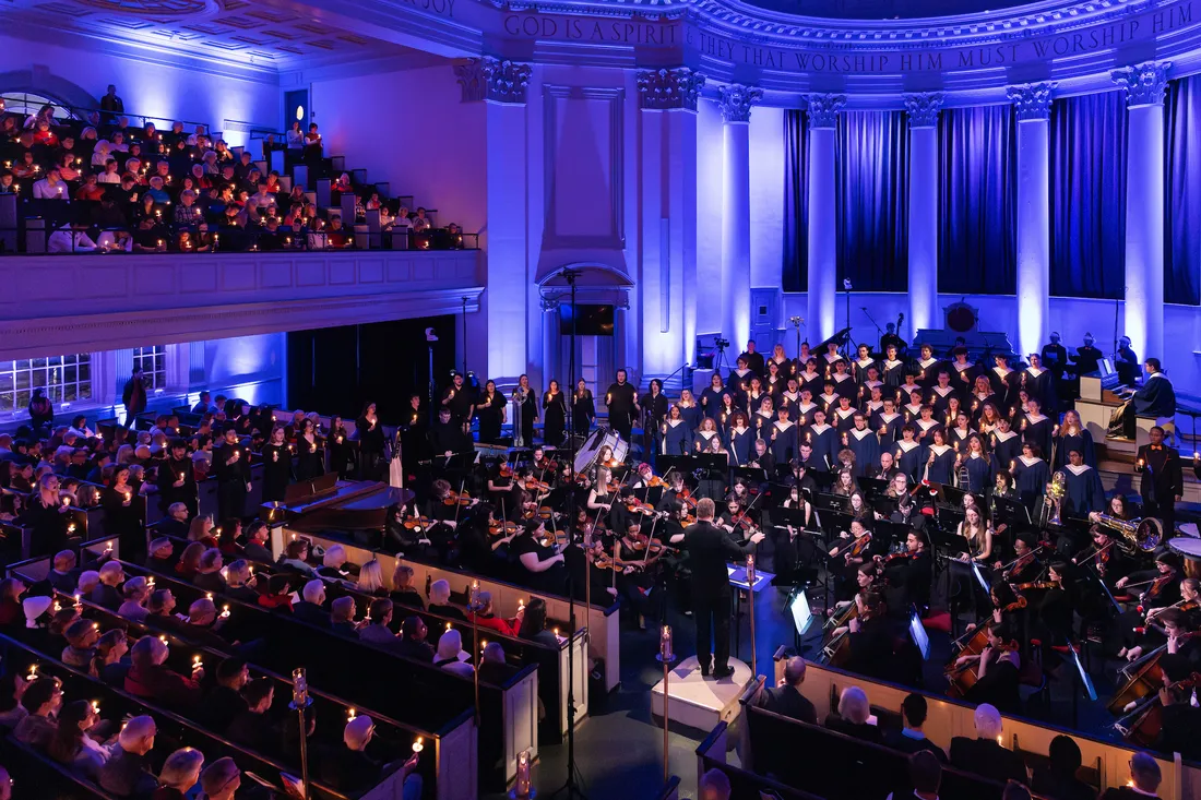 People singing in a choir in front of an audience.