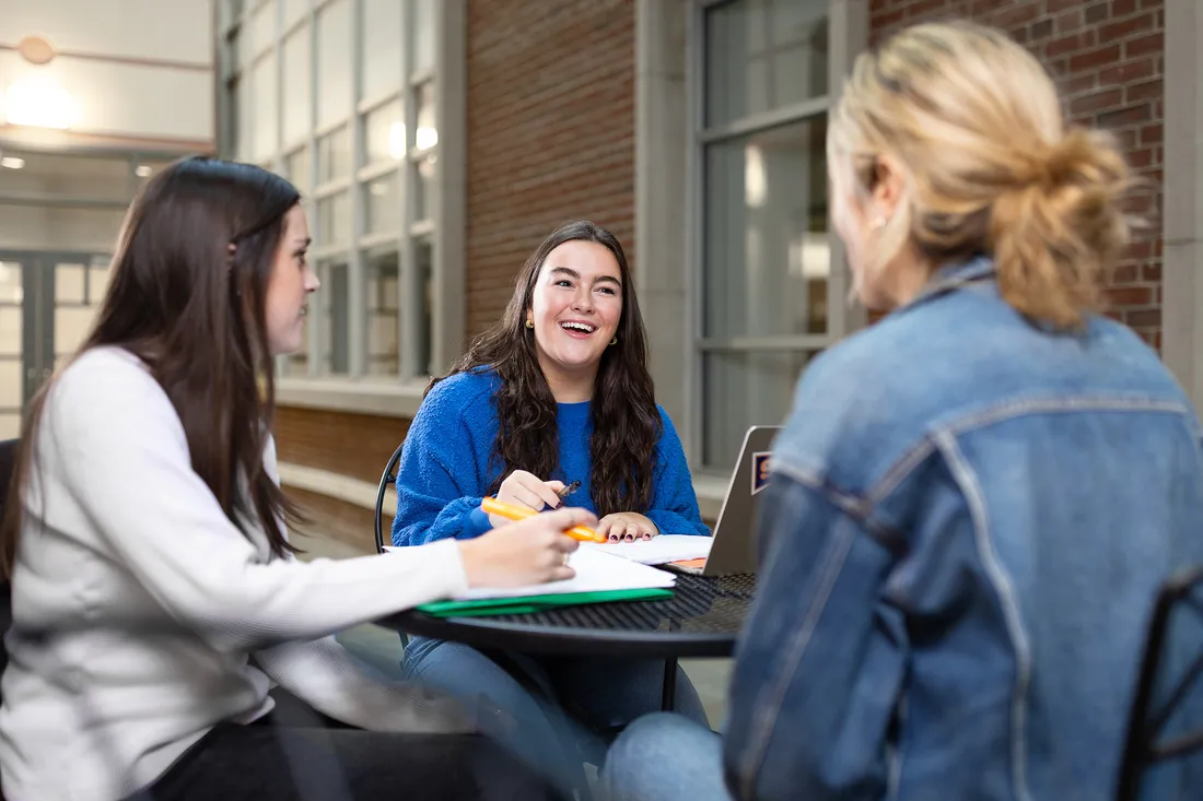 Student Katherine Waters sits at a table with friends.