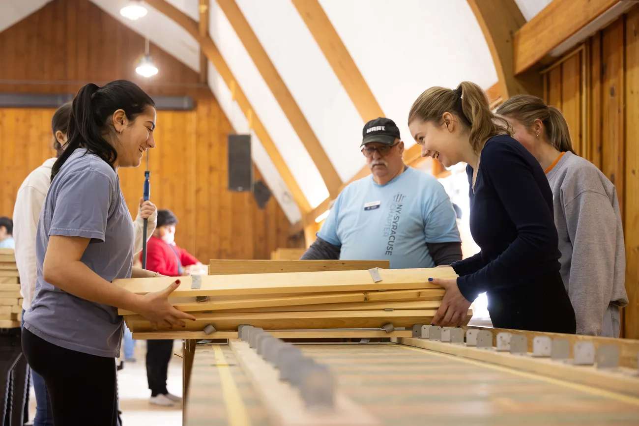 Students from the campus volunteer organization work together to build beds for local children for the local community group, Sleep in Heavenly Peace, Spring 2025