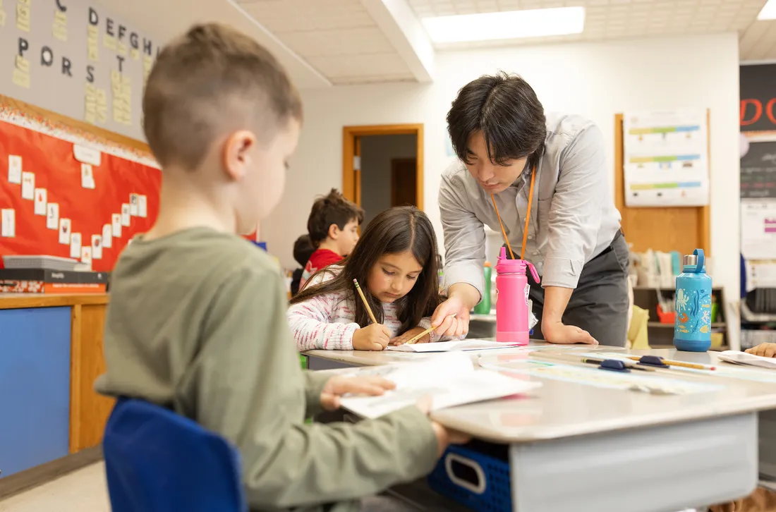 Student teacher teaching children in a classroom.