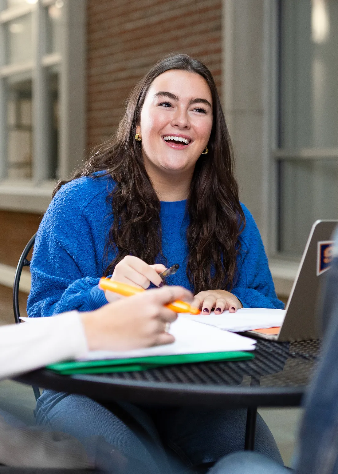 Katherine Waters sitting at a table smiling with another student.