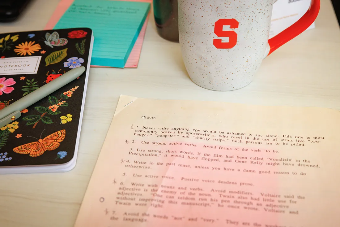 View of a desk with paper, notebook, and coffee mug.