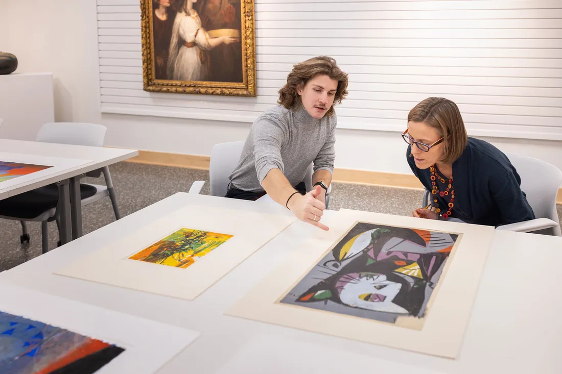 Patrick Holton and Sascha Scott looking at paintings together.