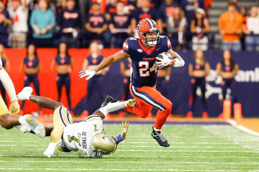 Will Nixon running on the field carrying a football.