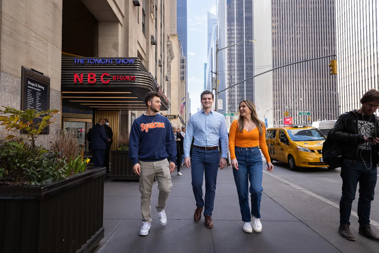 Three students walking down the street in New York City.