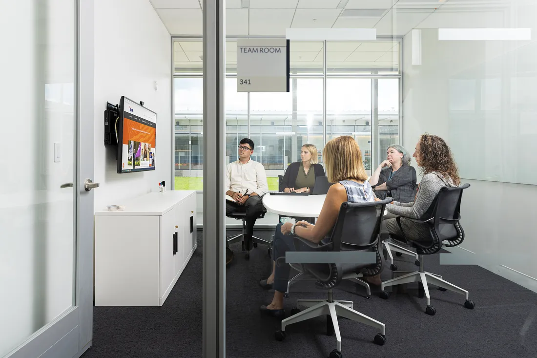 People sitting at a table inside a classroom.