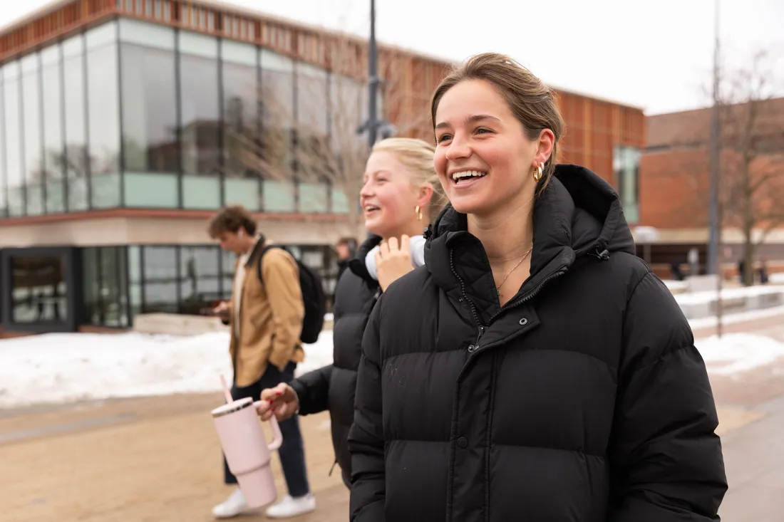 Students walking outside smiling and laughing.